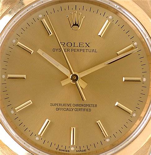 This image shows a close-up of the dial of a Rolex Oyster Perpetual 14208 Men's Yellow Gold Champagne Dial 14208 Men's Yellow Gold Champagne Dial watch, highlighting the hands, indices, and logo.