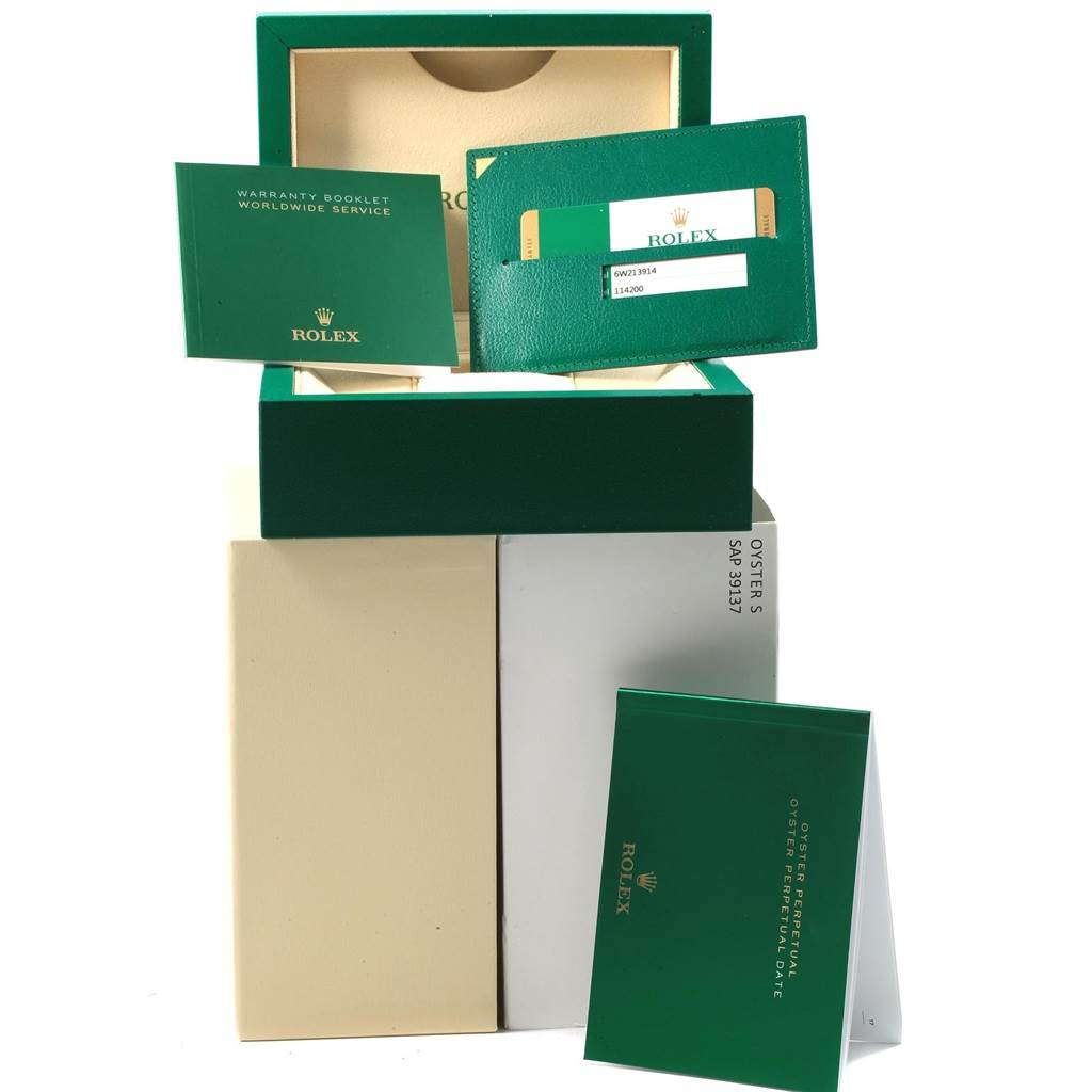 The image shows Rolex Oyster Perpetual 114200 Men's Stainless Steel Burgundy Dial 114200 Men's Stainless Steel Burgundy Dial packaging, including a box, warranty booklet, and authenticity card, viewed from the front.