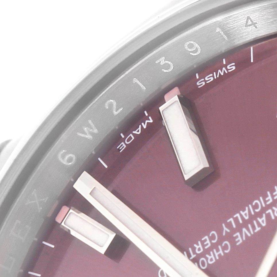 The image shows a close-up of the dial and markers of a Rolex Oyster Perpetual 114200 Men's Stainless Steel Burgundy Dial 114200 Men's Stainless Steel Burgundy Dial watch.