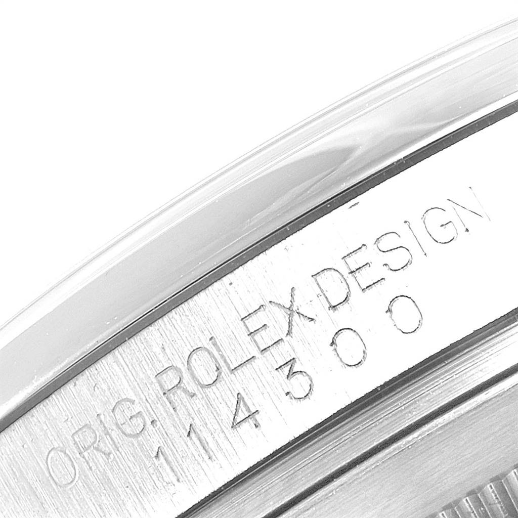 The image shows a close-up of the side of the Rolex Oyster Perpetual 114300 Men's Stainless Steel Burgundy Dial 114300 Men's Stainless Steel Burgundy Dial watch, displaying the model number and "ROLEX DESIGN" engraving.