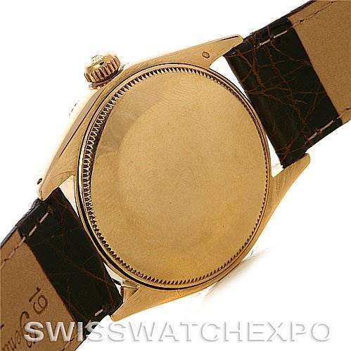 This image shows the back case and part of the leather strap of a Rolex Oyster Perpetual Men's Yellow Gold White Dial Men's Yellow Gold White Dial watch.