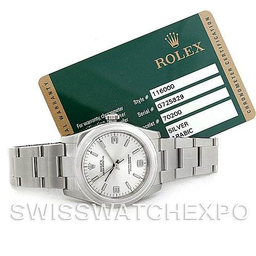 The image shows a Rolex Oyster Perpetual 116000 Men's Stainless Steel Silver Dial 116000 Men's Stainless Steel Silver Dial watch placed flat, with its warranty card visible in the background.