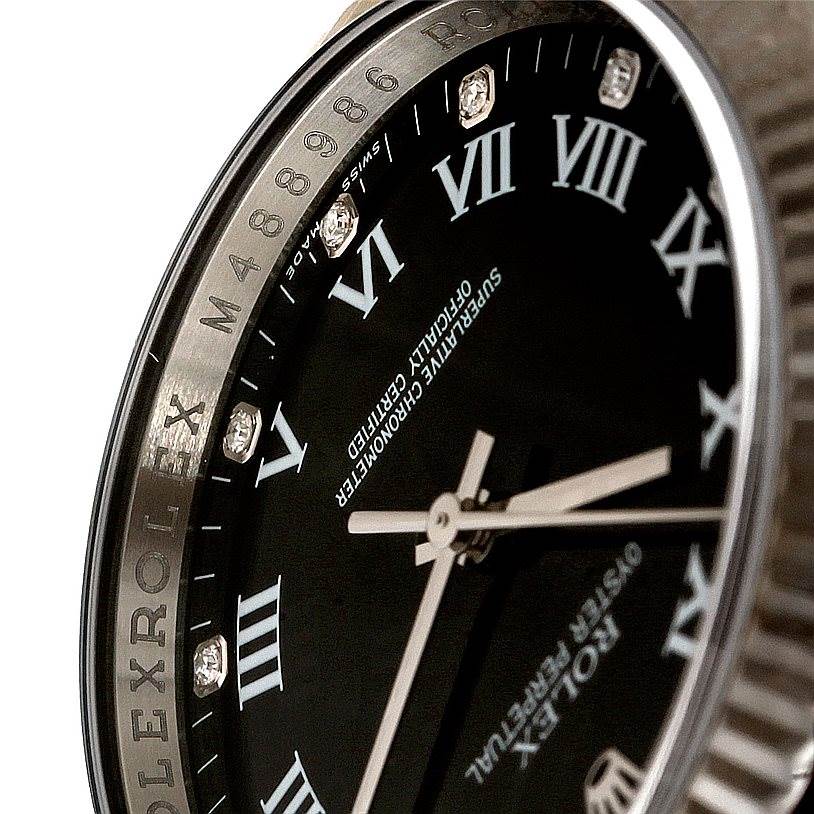 The image shows a close-up view of the dial and bezel of the Rolex Oyster Perpetual 116034 Men's Stainless Steel Black Dial 116034 Men's Stainless Steel Black Dial watch, highlighting the Roman numerals and bezel engraving.