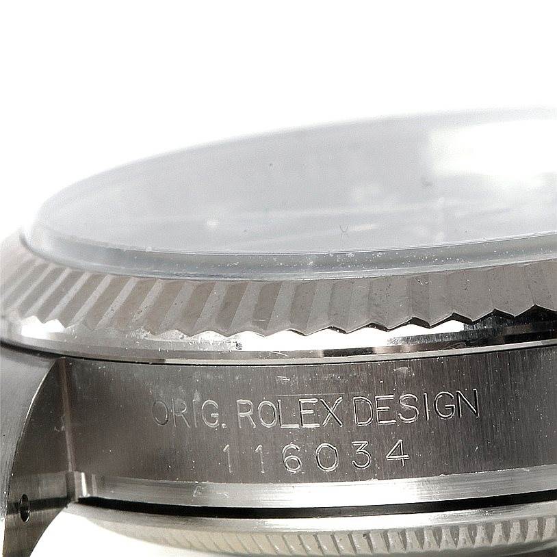 The image shows a close-up, side view of the bezel and case side of the Rolex Oyster Perpetual 116034 Men's Stainless Steel Black Dial 116034 Men's Stainless Steel Black Dial, displaying its engraved model number.