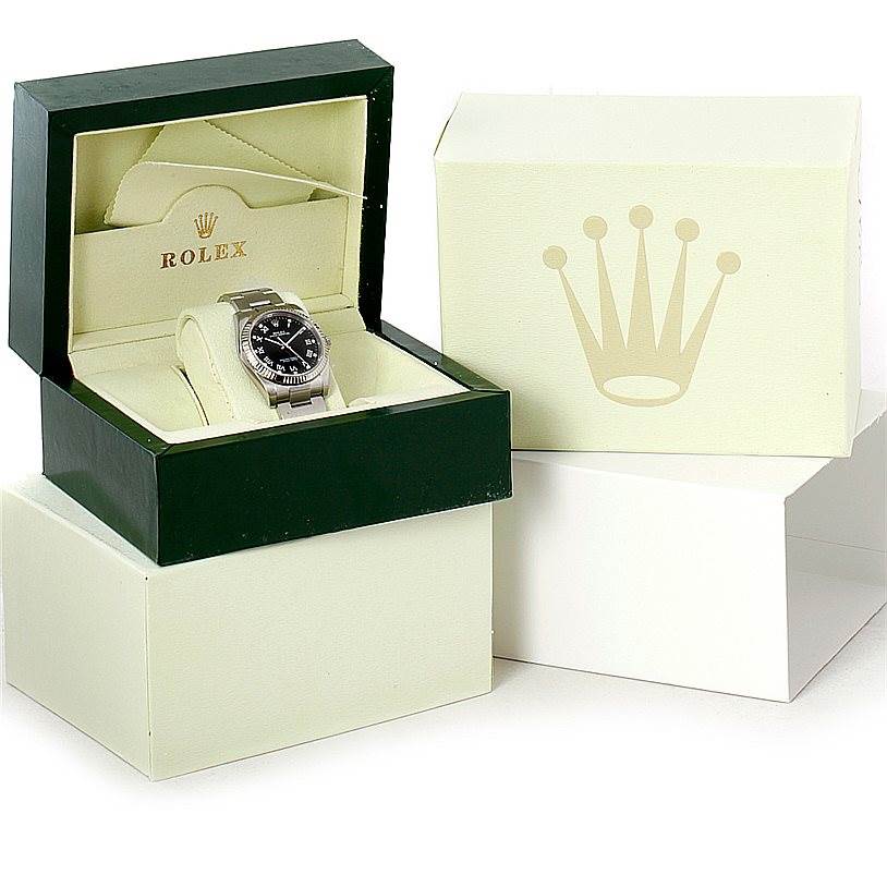 This image shows a Rolex Oyster Perpetual 116034 Men's Stainless Steel Black Dial 116034 Men's Stainless Steel Black Dial watch in its open green and beige presentation box, with a larger outer box beside it.