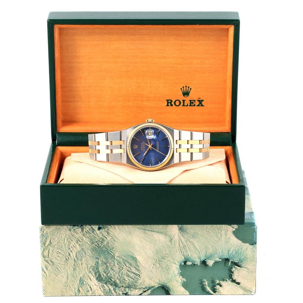 The Rolex Oysterquartz 17013 Men's Stainless Steel Blue Dial 17013 Men's Stainless Steel Blue Dial watch is shown from the front, displayed in an open green and tan box.