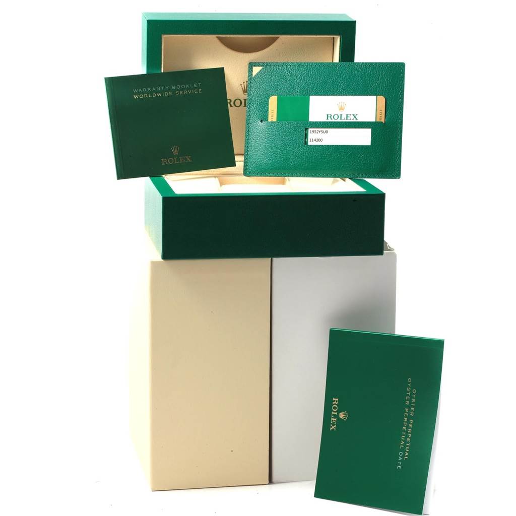 This image shows a Rolex Oysterquartz 114200 Men's Stainless Steel Burgundy Dial 114200 Men's Stainless Steel Burgundy Dial packaging with warranty booklets and a green Rolex card from a frontal angle.