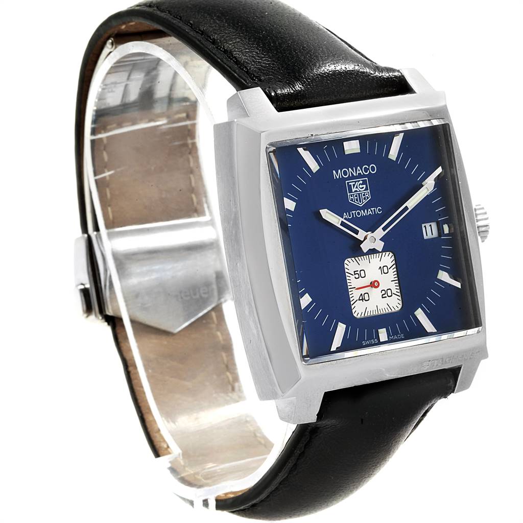 The image shows a side angle of the Tag Heuer Monaco WW2111.FC6204 Men's Stainless Steel Blue Dial WW2111.FC6204 Men's Stainless Steel Blue Dial watch, featuring its black leather strap, blue dial, and square stainless steel case.