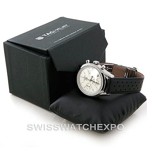This image shows a Tag Heuer Classic model watch on a black cushion with its branded box in the background.