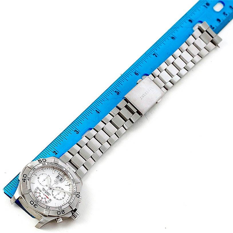 The Tag Heuer Aquaracer CAF101B Men's Stainless Steel Silver Dial CAF101B Men's Stainless Steel Silver Dial watch is shown from a top-down angle, displaying the face, bezel, and stainless steel bracelet alongside a blue ruler.