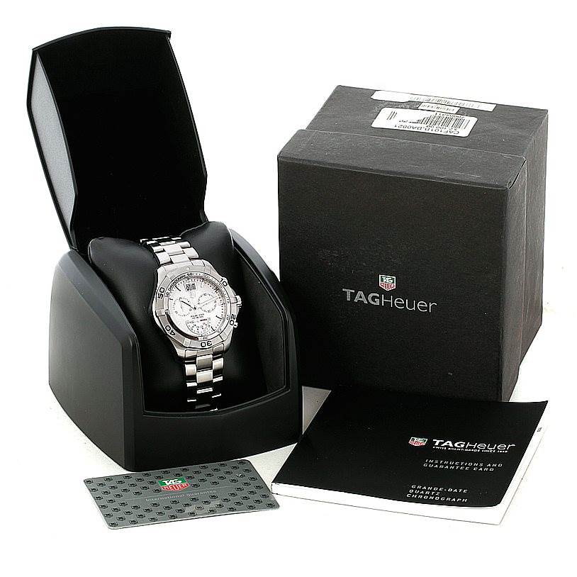 The image shows a Tag Heuer Aquaracer CAF101B Men's Stainless Steel Silver Dial CAF101B Men's Stainless Steel Silver Dial watch in its opened case, alongside its box, warranty card, and instruction manual.