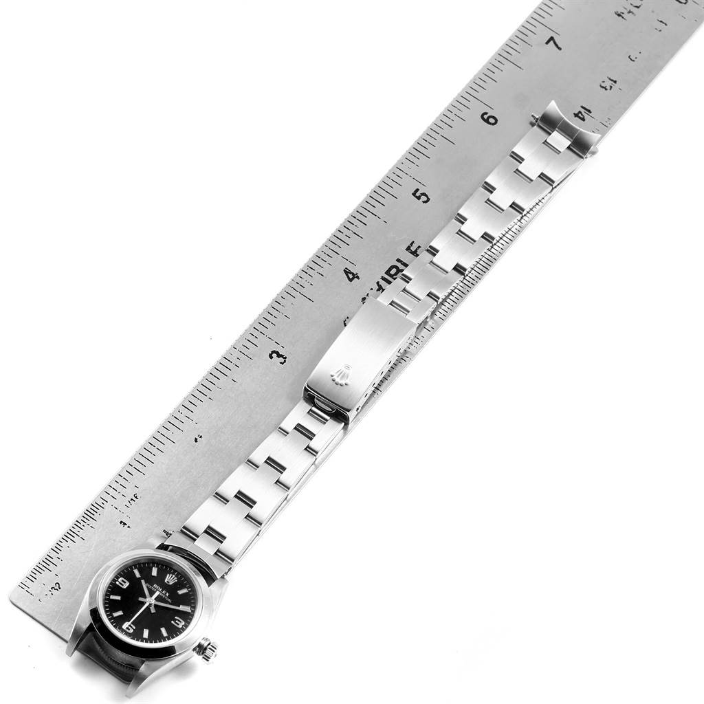 The image shows a Rolex Oyster Perpetual 76080 Women's Stainless Steel Black Dial 76080 Women's Stainless Steel Black Dial watch with its band and clasp laid flat next to a ruler for measurement.