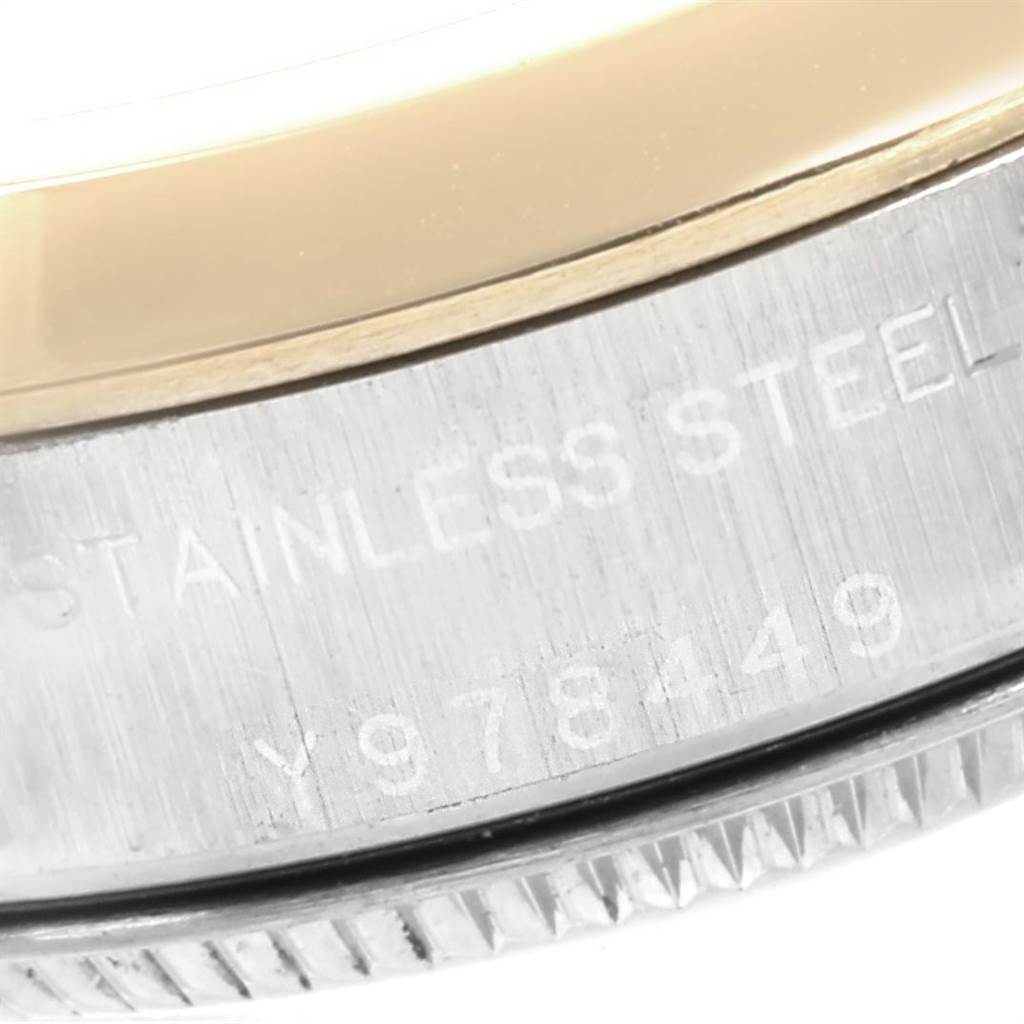 This close-up image shows the side of a Rolex Oyster Perpetual 76183 Women's Steel and Gold (two tone) Grey Dial 76183 Women's Steel and Gold (two tone) Grey Dial watch, highlighting the stainless steel and the inscription.
