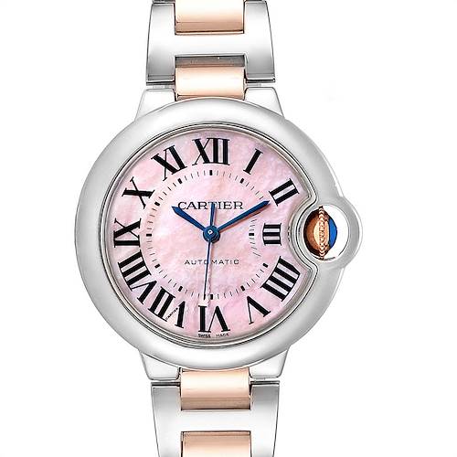 The image shows a front view of a Cartier Ballon Bleu W6920098 Women's Steel and Gold (two tone) Mother of Pearl Dial W6920098 Women's Steel and Gold (two tone) Mother of Pearl Dial watch, highlighting its pink dial, Roman numerals, and metal bracelet.