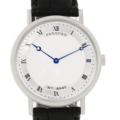 The image shows a front view of a Breguet Classique 5157 Men's White Gold Silver Dial 5157 Men's White Gold Silver Dial watch with Roman numerals, blue hands, and a black leather strap.