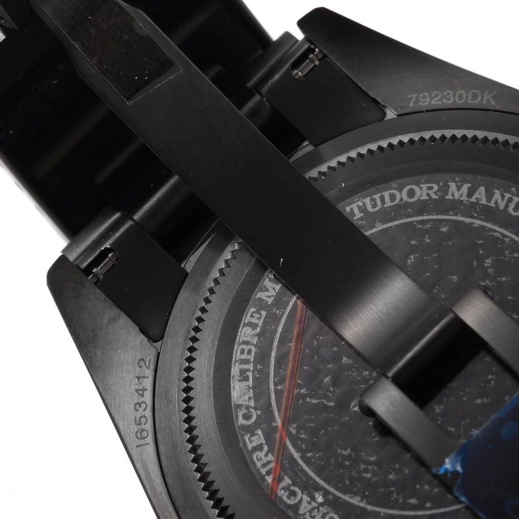 The image shows the back of the Tudor Heritage Black Bay 79230DK Men's Stainless Steel Black Dial 79230DK Men's Stainless Steel Black Dial watch, including detailed engravings and part of the bracelet.