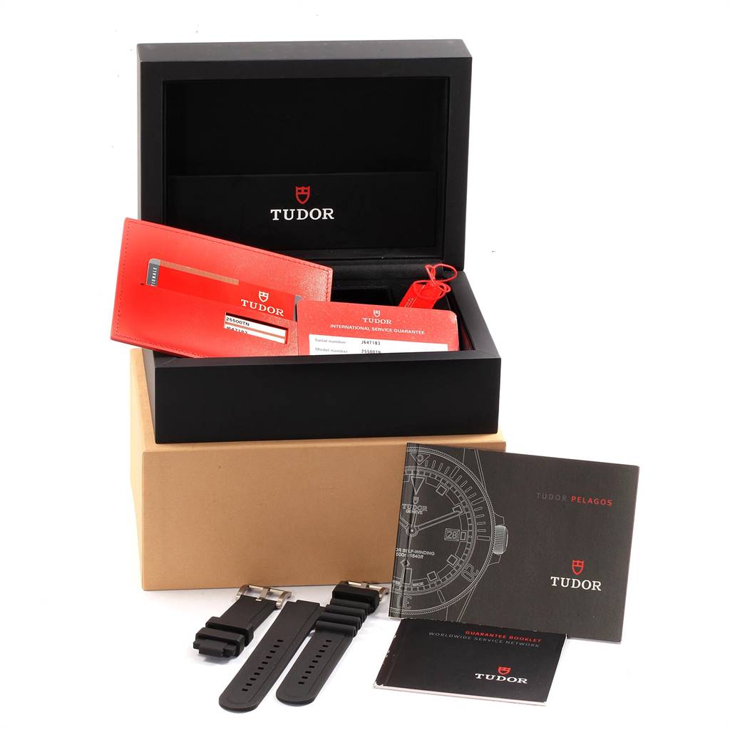 This image shows the Tudor Pelagos 25500TN Men's Titanium Black Dial 25500TN Men's Titanium Black Dial box, manual, warranty card, and extra straps arranged neatly in a display.