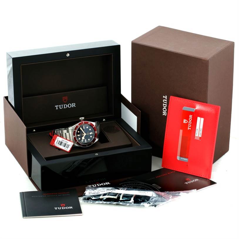 The image shows a Tudor Heritage Black Bay 79220 Men's Stainless Steel Black Dial 79220 Men's Stainless Steel Black Dial watch in its open box with additional accessories and documents.
