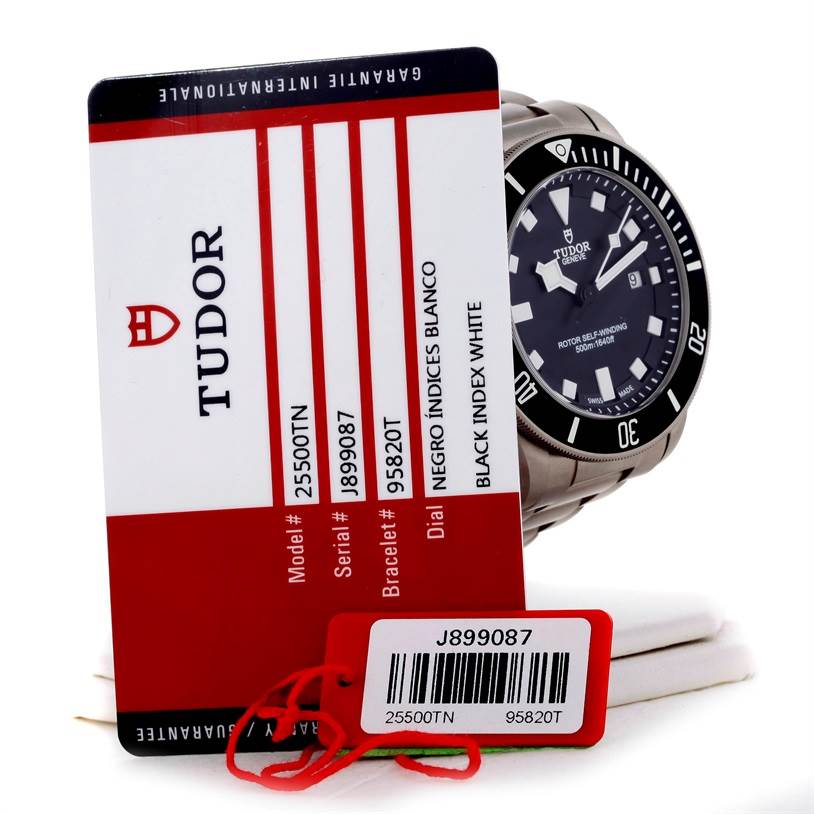 The Tudor Pelagos 25500TN Men's Titanium Black Dial 25500TN Men's Titanium Black Dial watch is shown at an angled view alongside its warranty card and tag.