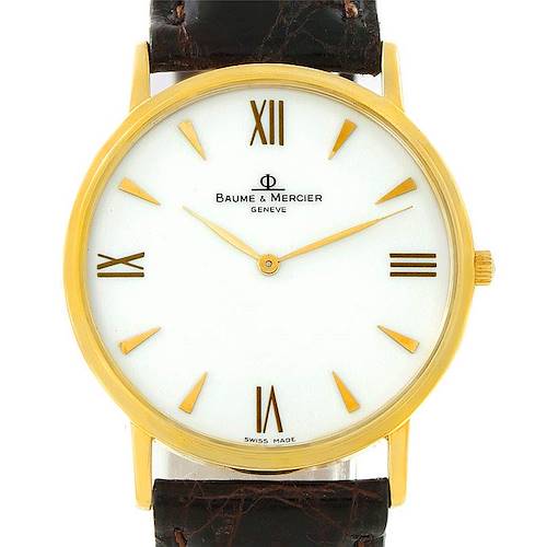 The image shows a front view of a Baume & Mercier Classima 8069 Men's Yellow Gold White Dial 8069 Men's Yellow Gold White Dial watch, featuring a gold case, white dial, and a black leather strap.