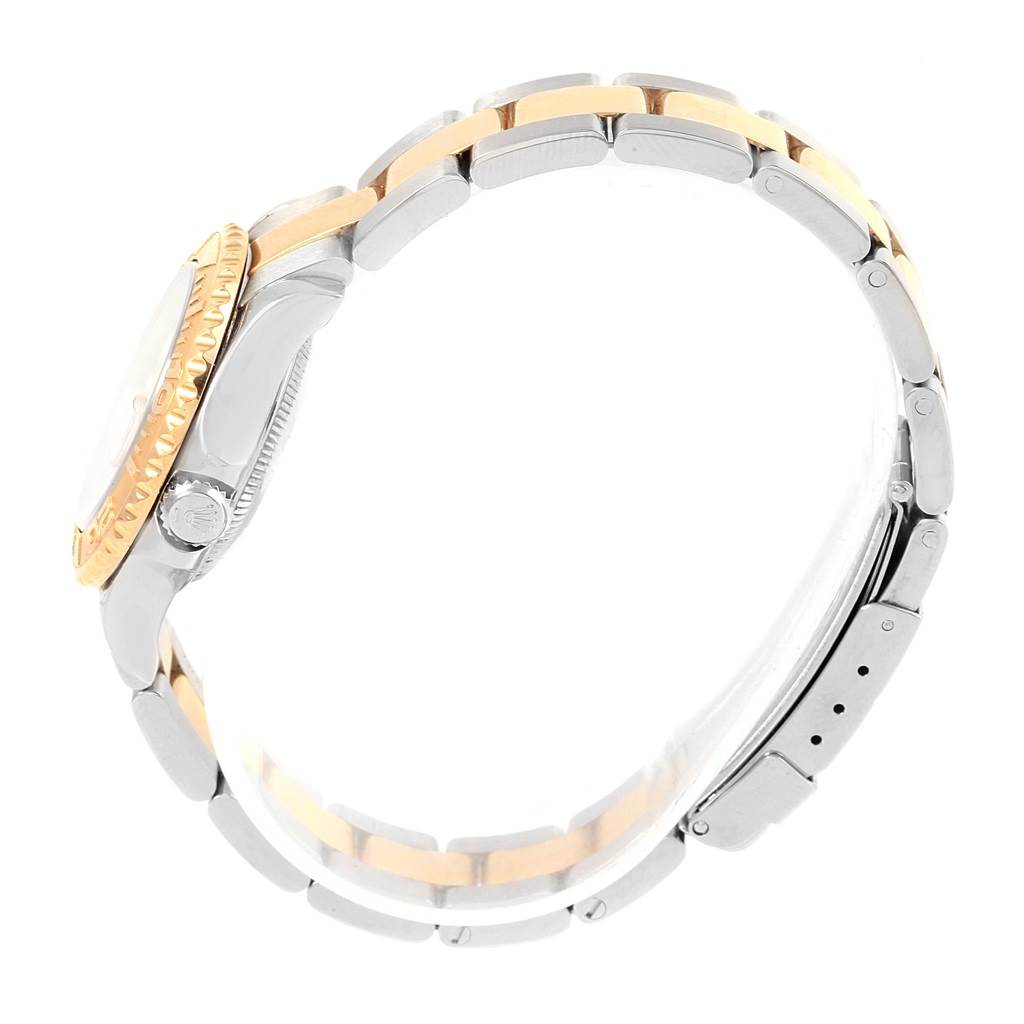 The image shows a side view of the Yacht-Master model by Rolex, highlighting the crown, case, and two-tone bracelet.