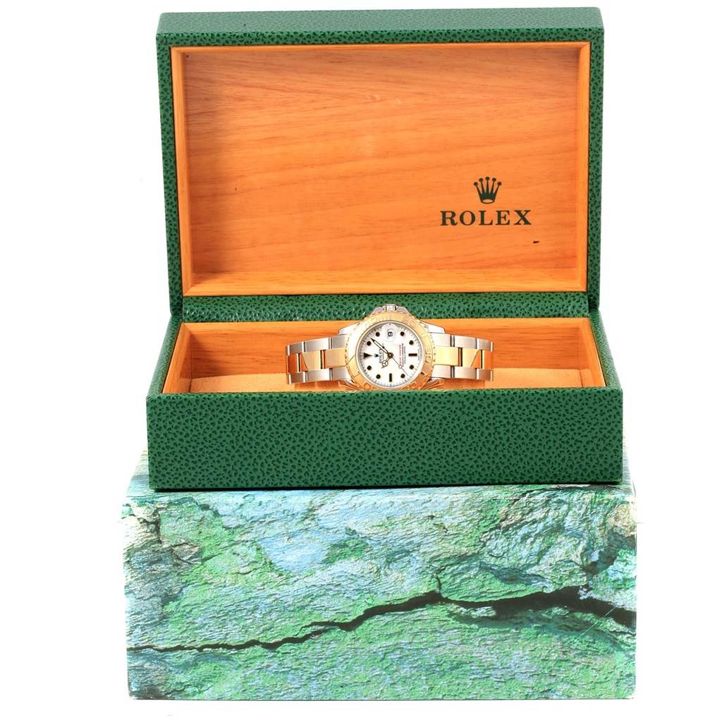 This image shows a Rolex Yacht-Master 169623 Women's Steel and Gold (two tone) White Dial 169623 Women's Steel and Gold (two tone) White Dial watch in an open green and wood-textured Rolex box, viewed from the front.