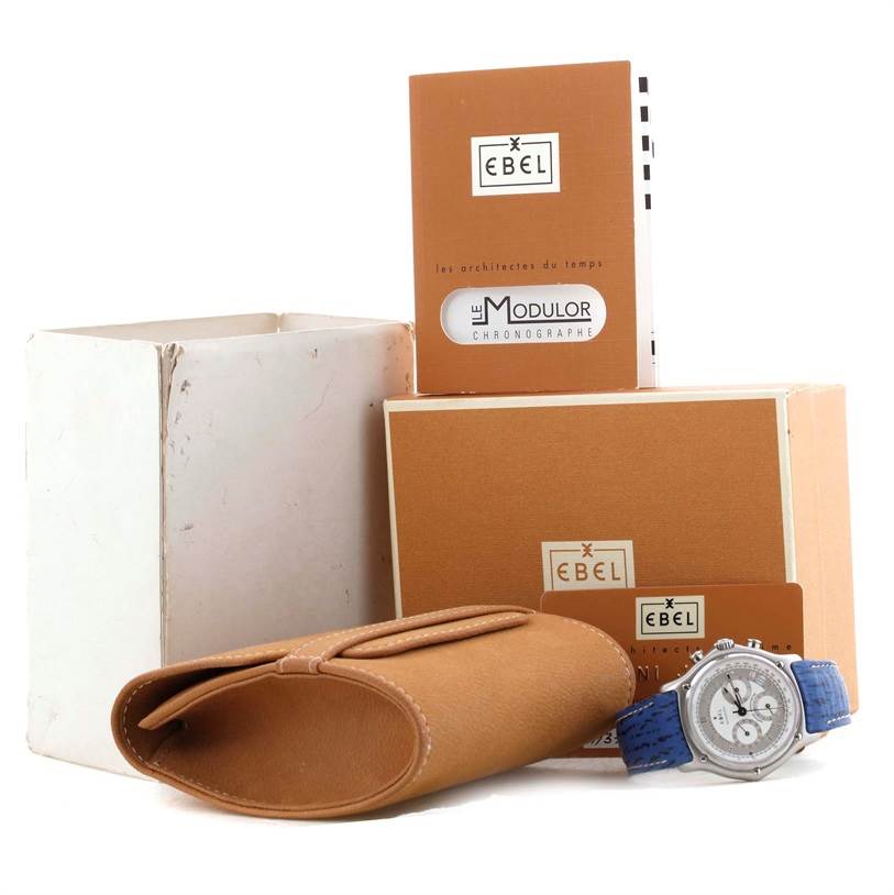 The image shows the Ebel 9137241 Stainless Steel Silver Dial 9137241 Stainless Steel Silver Dial Le Modulor Automatic Chronograph Blue Strap Watch 9137241 with its box, papers, and a brown leather case.