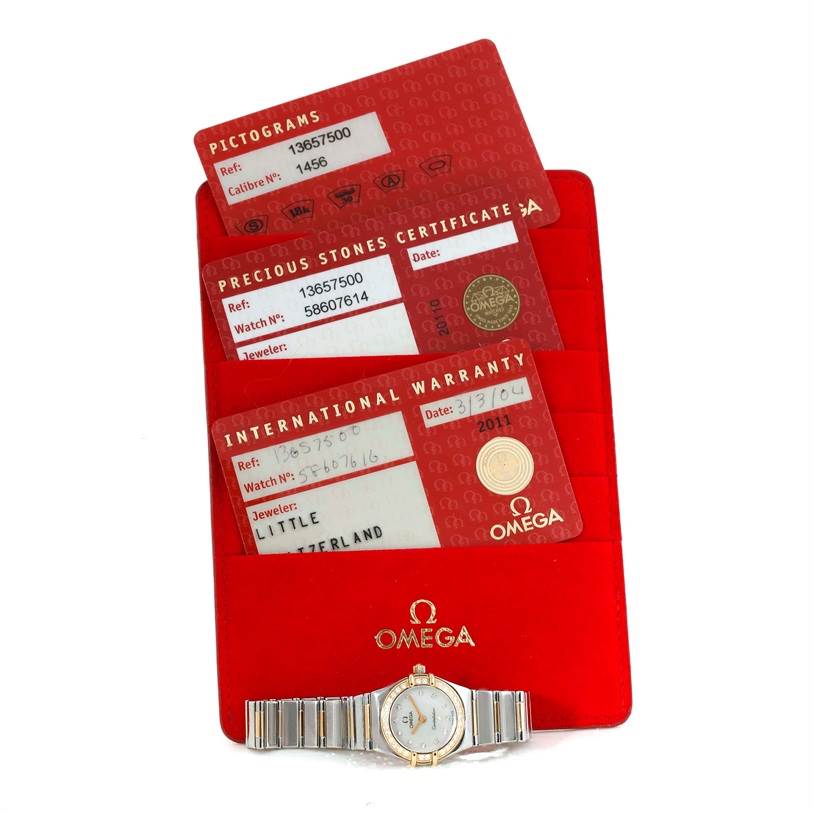 The image shows the Omega 1365.75.00 Women's Steel and Gold (two tone) Mother of Pearl Dial 1365.75.00 Women's Steel and Gold (two tone) Mother of Pearl Dial Constellation Mini Steel Yellow Gold Diamond Watch 1365.75.00 with its warranty cards and certificates.