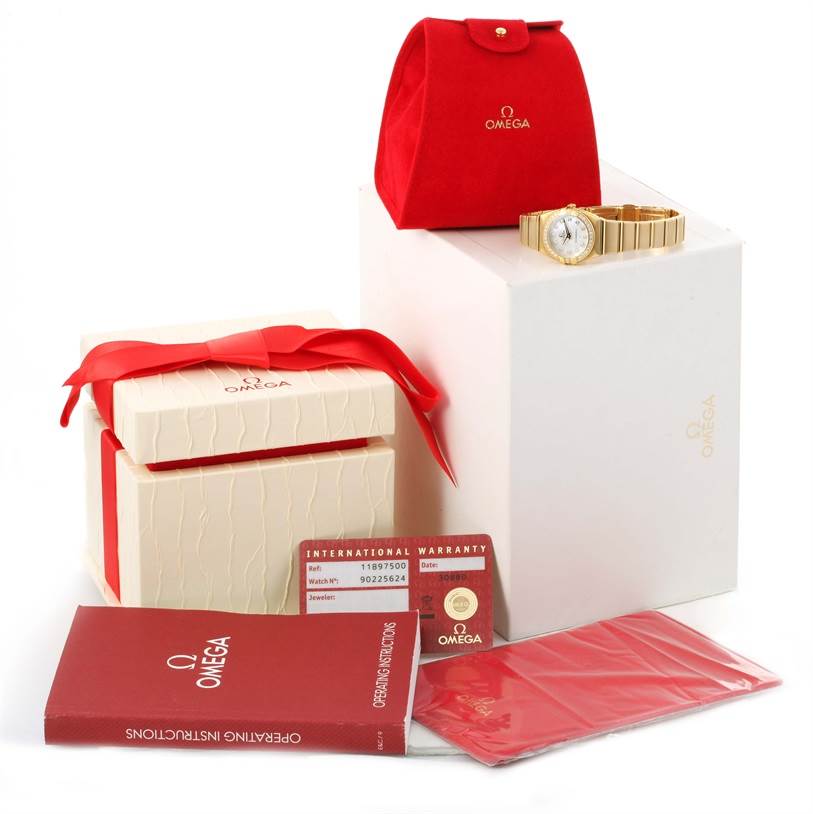 The image shows an Omega 1189.75.00 Women's Yellow Gold Mother of Pearl Dial 1189.75.00 Women's Yellow Gold Mother of Pearl Dial Constellation Double Eagle Yellow Gold Diamond Watch 1189.75.00 with its box, pouch, operating instructions, and warranty card.