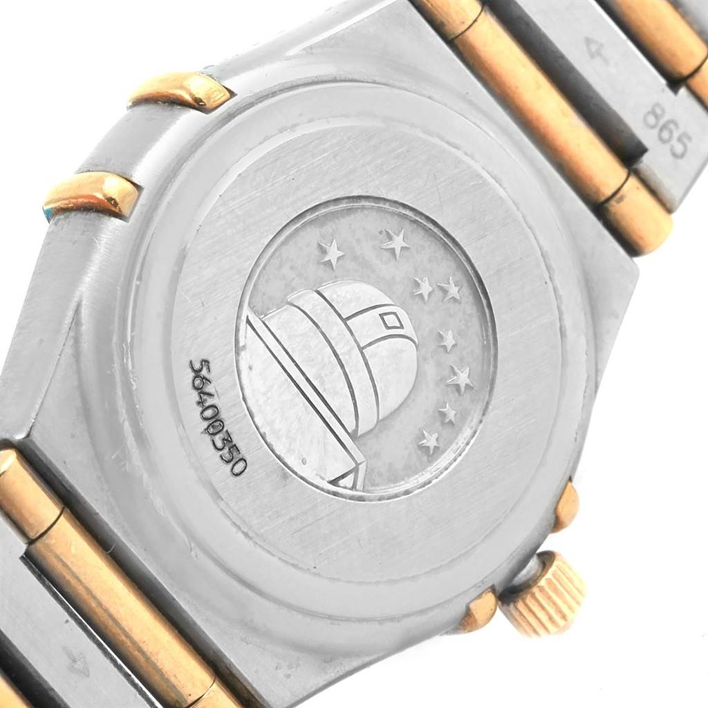 The image shows the case back and part of the bracelet of an Omega 1267.75.00 Women's Steel and Gold (two tone) Mother of Pearl Dial 1267.75.00 Women's Steel and Gold (two tone) Mother of Pearl Dial Constellation Mini MOP Diamond Ladies Watch 1267.75.00, featuring an observatory engraving.