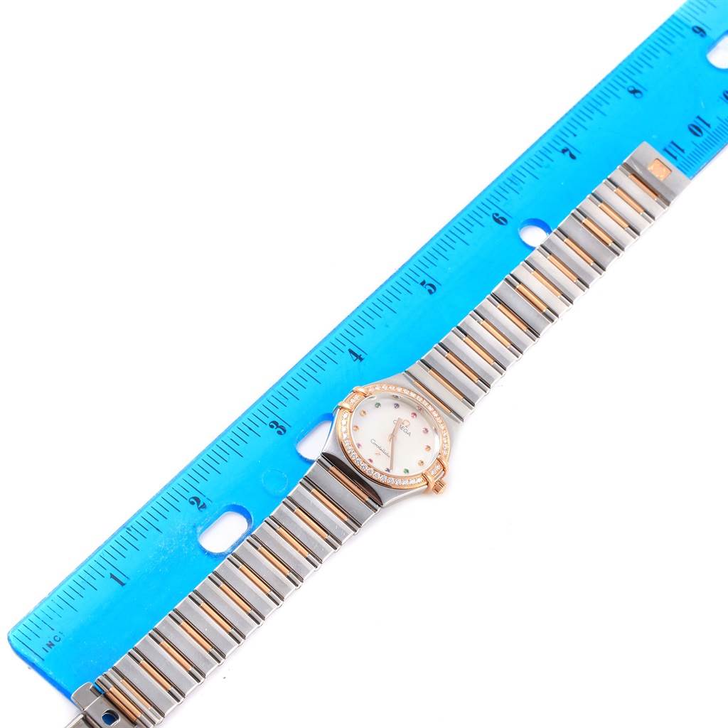 The Omega 1465.79.00 Women's Steel and Gold (two tone) Mother of Pearl Dial 1465.79.00 Women's Steel and Gold (two tone) Mother of Pearl Dial Constellation Iris My Choice Steel Rose Gold Ladies Watch 1373.79 is shown from an overhead angle with a ruler for scale.