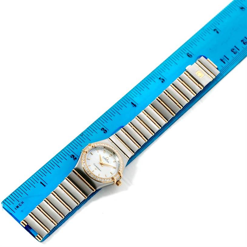 The Omega 1277.70.00 Women's Steel and Gold (two tone) Mother of Pearl Dial 1277.70.00 Women's Steel and Gold (two tone) Mother of Pearl Dial Constellation My Choice Steel Gold Diamond Watch 1277.70.00 is shown from a top-down angle, alongside a ruler.