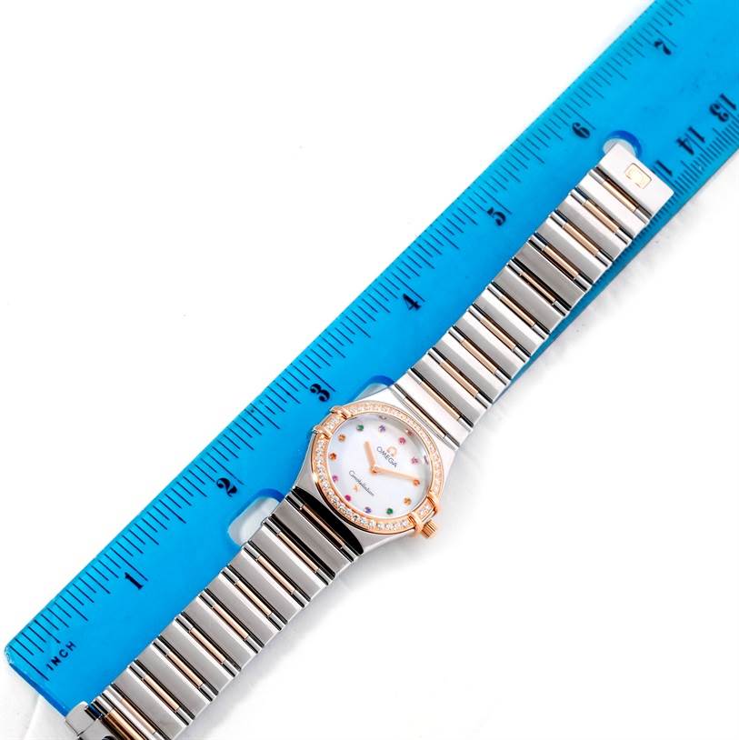 The Omega 1358.79.00 Women's Steel and Gold (two tone) Mother of Pearl Dial 1358.79.00 Women's Steel and Gold (two tone) Mother of Pearl Dial Constellation Iris 1358.79.00 watch is shown from above, with the face, bracelet, and part of a blue ruler visible.