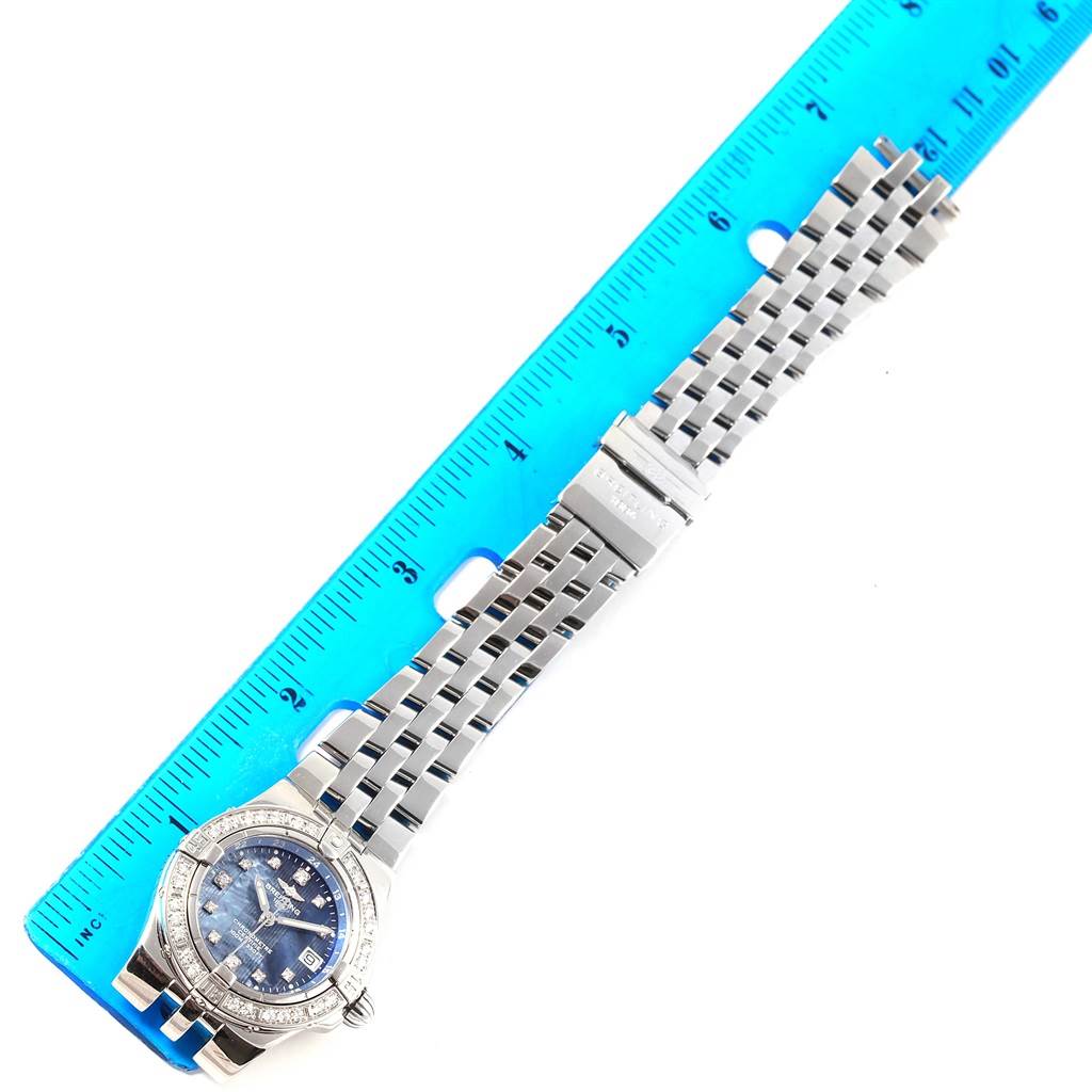 The Breitling A71340 Women's Stainless Steel Mother of Pearl Dial A71340 Women's Stainless Steel Mother of Pearl Dial Starliner Blue Mother of Pearl Diamond Watch A71340 is shown in a top-down angle, highlighting the face, bracelet, and a measuring ruler.