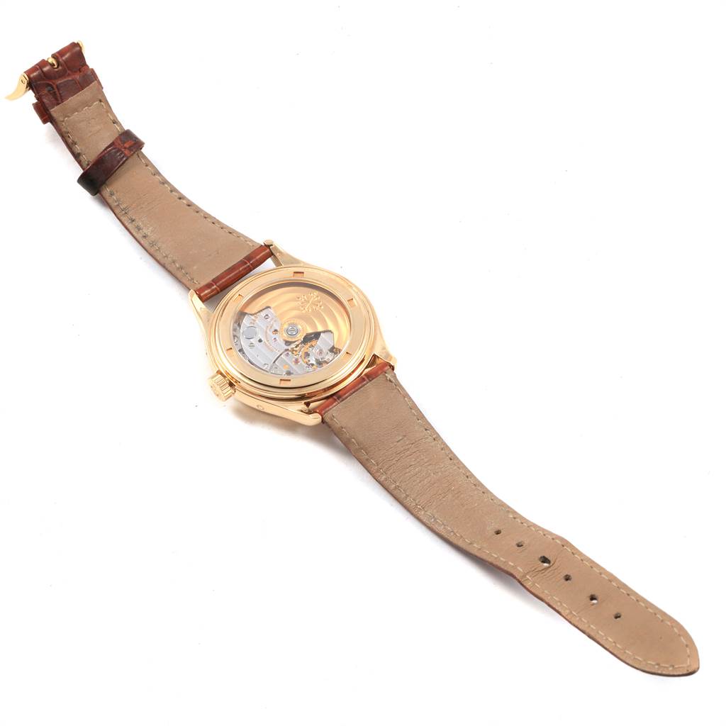 This image shows the back view of a Patek Philippe 5035J Men's Yellow Gold Silver Dial 5035J Men's Yellow Gold Silver Dial Complicated Annual Calendar Yellow Gold Mens Watch 5035 model, displaying the movement and strap.