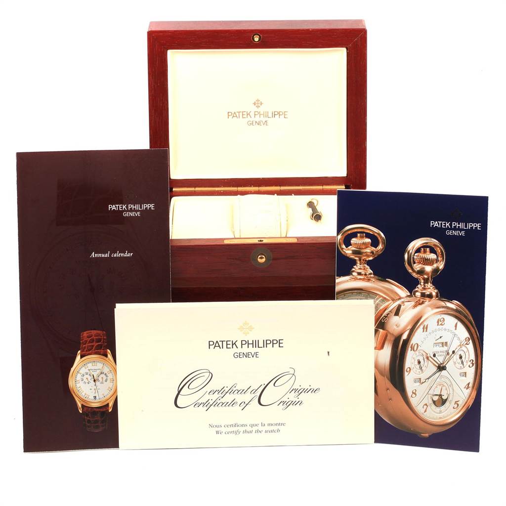 The image shows the packaging, manuals, and Certificate of Origin for the Patek Philippe 5035J Men's Yellow Gold Silver Dial 5035J Men's Yellow Gold Silver Dial 5035 Complicated Annual Calendar Yellow Gold Men's Watch.
