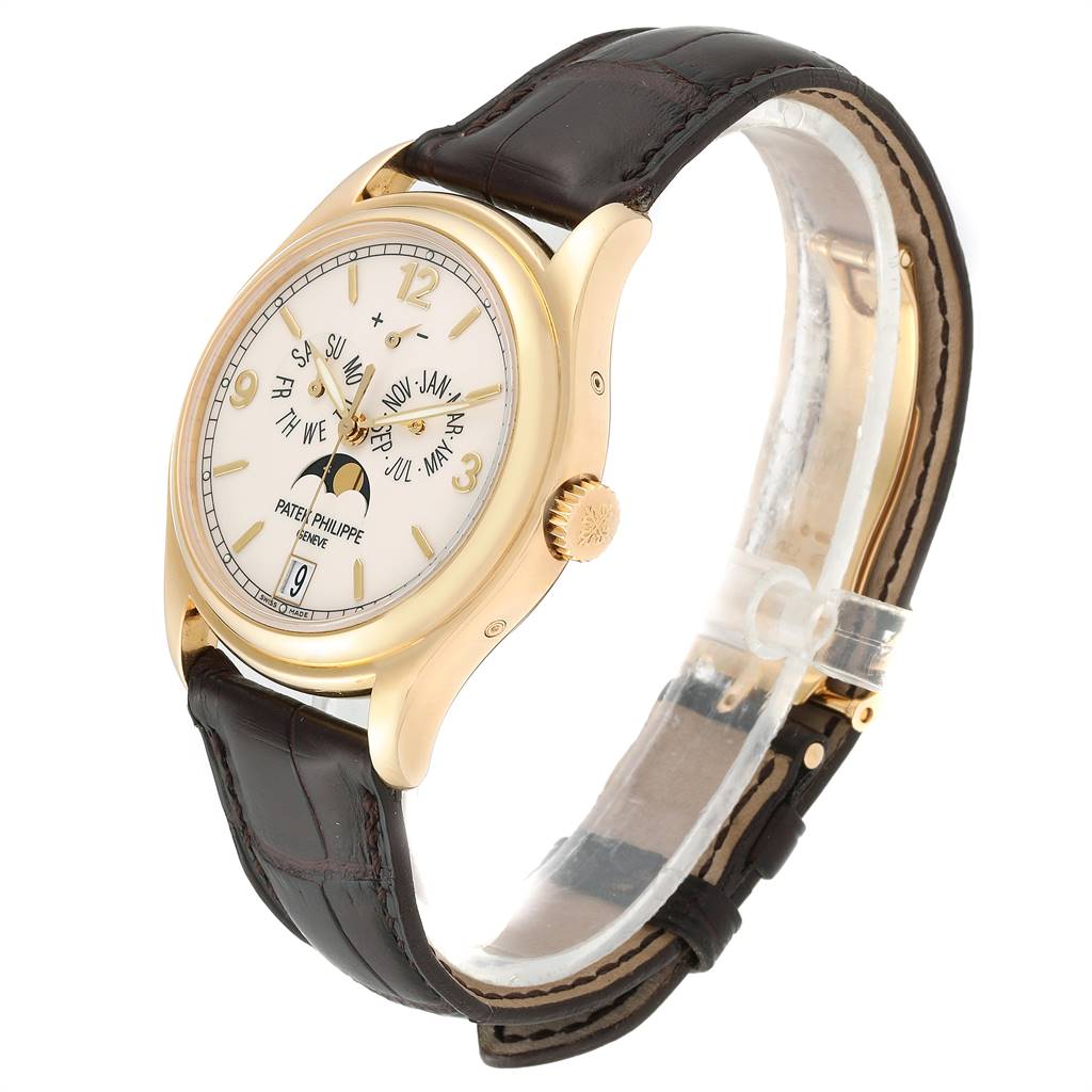 The Patek Philippe 5146J Men's Yellow Gold Beige Dial 5146J Men's Yellow Gold Beige Dial Complicated Annual Calendar 5146J model is shown at a three-quarter angle, highlighting the yellow gold case and leather strap.