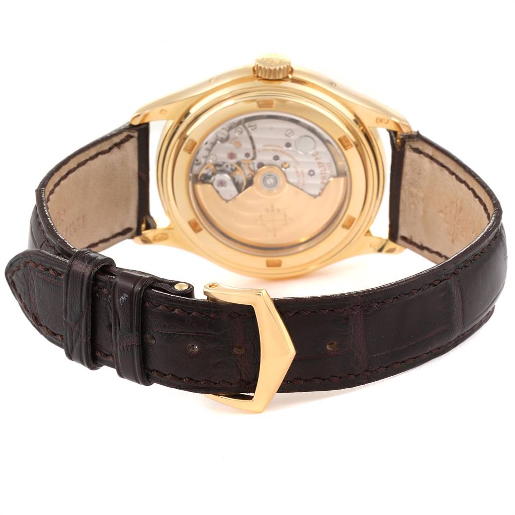 The image shows the back view of the Patek Philippe 5146J Men's Yellow Gold Beige Dial 5146J Men's Yellow Gold Beige Dial Complicated Annual Calendar Yellow Gold Mens Watch 5146J, highlighting its movement and leather strap.