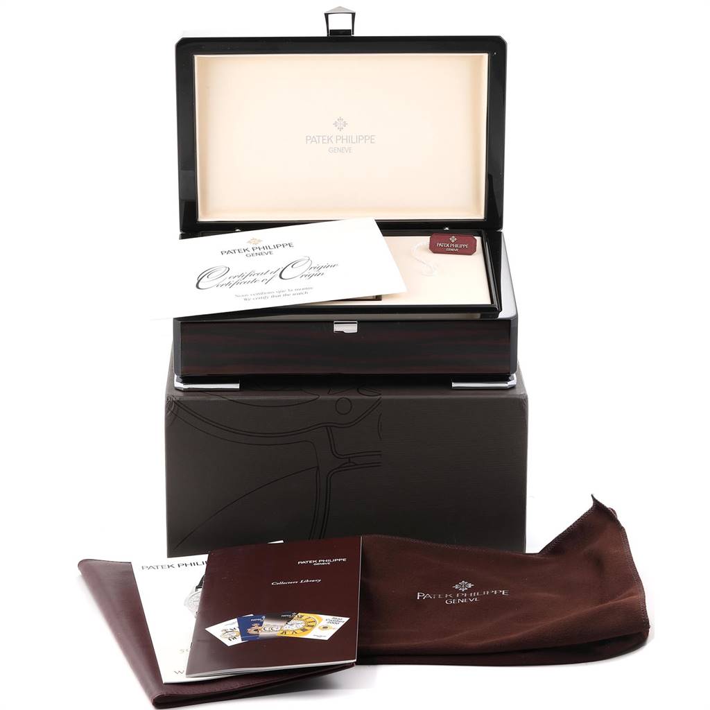 The image shows the packaging and accessories for a Patek Philippe Calatrava 5296G Men's White Gold Silver Dial 5296G Men's White Gold Silver Dial watch, including booklets and cloths, from a front angle.