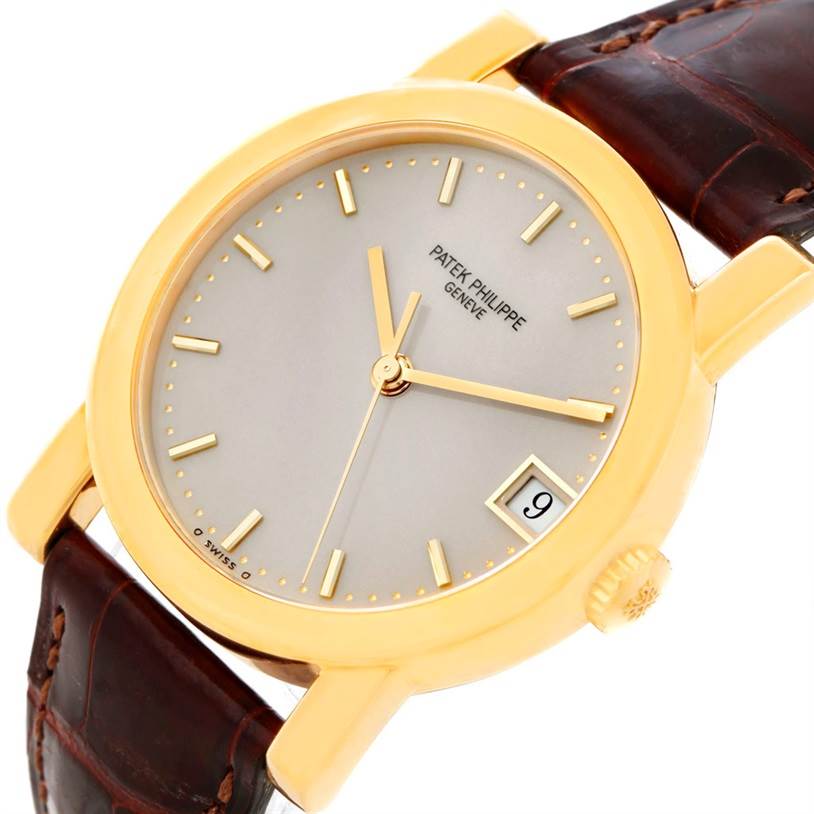 The Patek Philippe Calatrava 5012 Men's Yellow Gold Beige Dial 5012 Men's Yellow Gold Beige Dial watch is shown at an angled close-up, highlighting the face, crown, strap, and date window.
