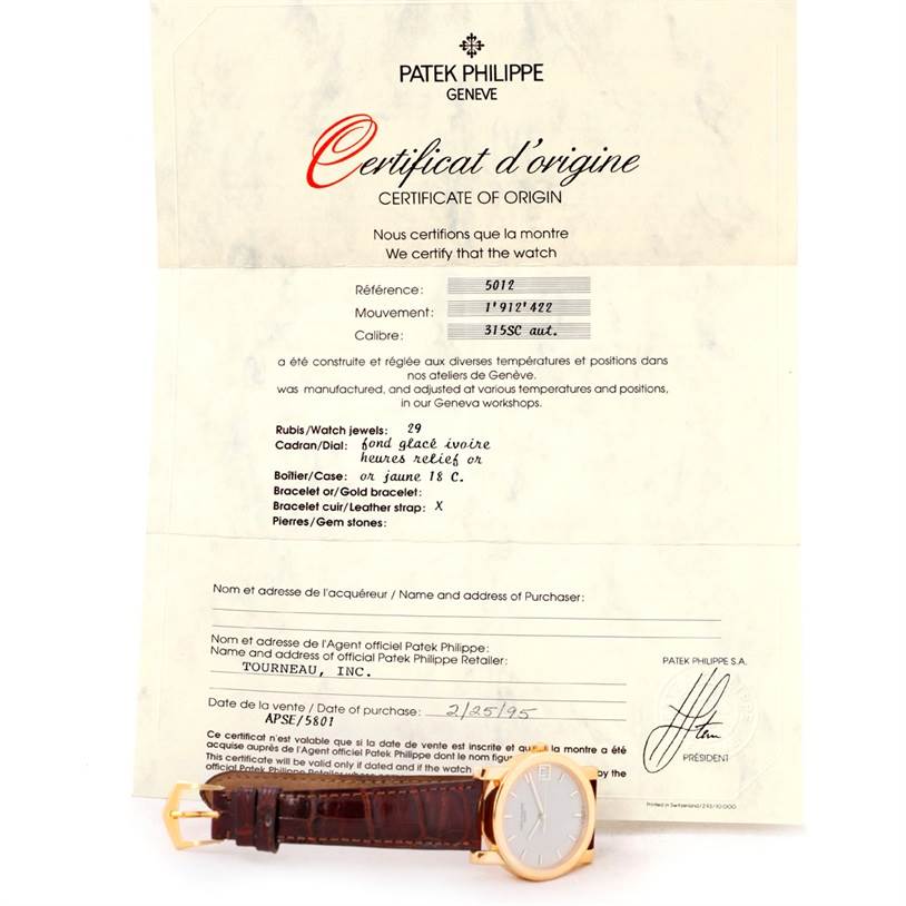The image shows a Patek Philippe Calatrava 5012 Men's Yellow Gold Beige Dial 5012 Men's Yellow Gold Beige Dial watch with a leather strap, placed next to its certificate of origin, viewed from the front.
