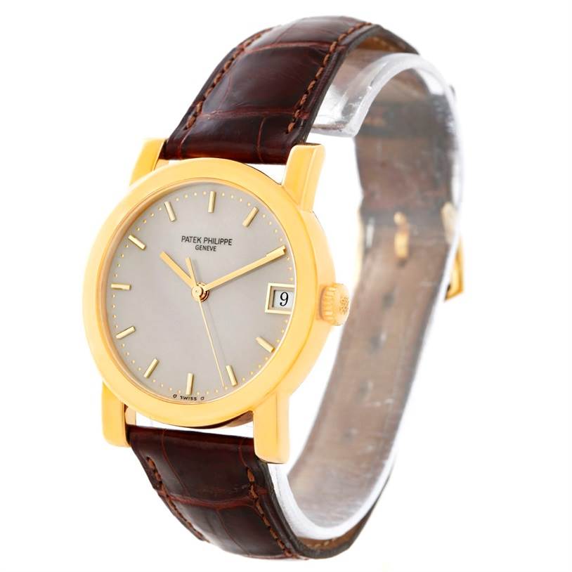 This image shows a Patek Philippe Calatrava 5012 Men's Yellow Gold Beige Dial 5012 Men's Yellow Gold Beige Dial watch at a three-quarter angle, highlighting the face, case, crown, and leather strap.