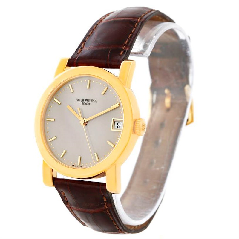 This image shows a Patek Philippe Calatrava 5012 Men's Yellow Gold Beige Dial 5012 Men's Yellow Gold Beige Dial watch at a three-quarter angle, highlighting the face, case, crown, and leather strap.