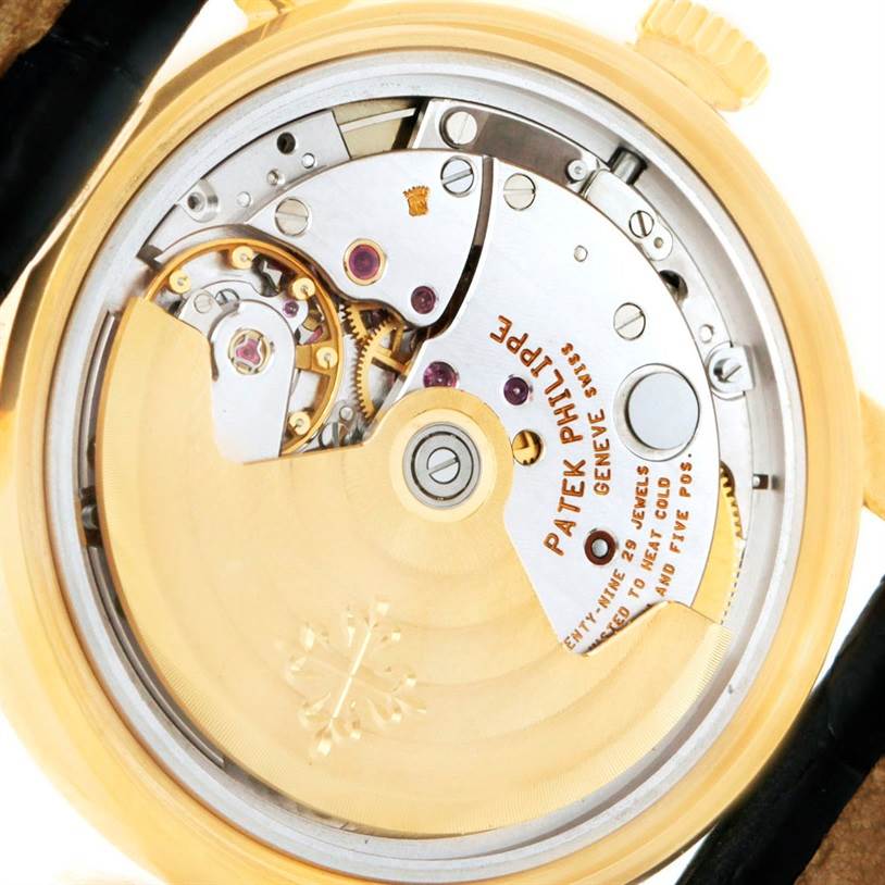 The image shows the back view of a Patek Philippe Calatrava 5012 Men's Yellow Gold Beige Dial 5012 Men's Yellow Gold Beige Dial watch, highlighting its intricate movement and mechanisms.