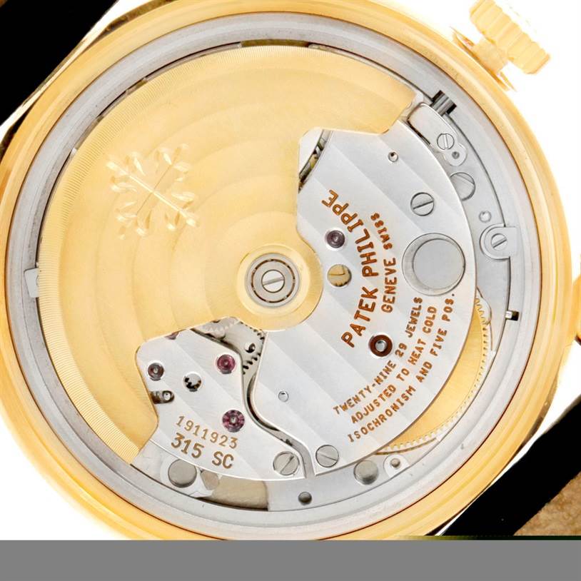 The image shows the back angle of the Patek Philippe Calatrava 5012 Men's Yellow Gold Beige Dial 5012 Men's Yellow Gold Beige Dial watch, highlighting its movement and internal mechanics.