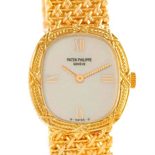 The image shows a close-up, front-facing view of a Vintage Patek Philippe watch, displaying its gold intricacies and woven bracelet.