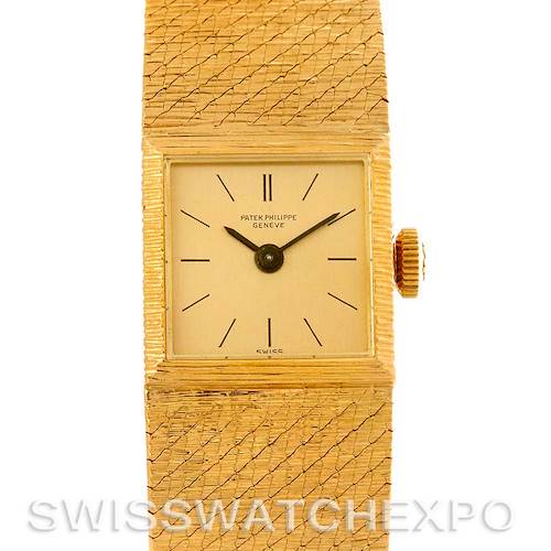 The image shows the dial and right side of the case of a vintage Patek Philippe watch, highlighting its gold watch face and textured band.