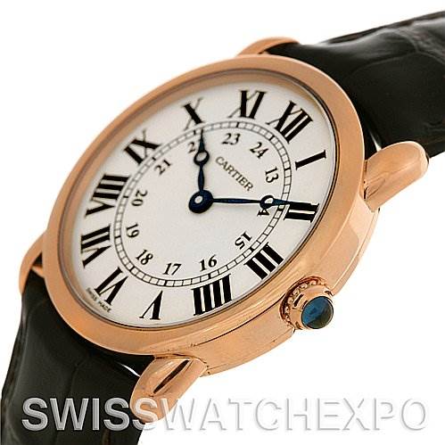 The image shows a close-up side angle of a Cartier Ronde W6800151 Women's Rose Gold Silver Dial W6800151 Women's Rose Gold Silver Dial model watch, highlighting its white dial, Roman numerals, and the crown with a blue gemstone.