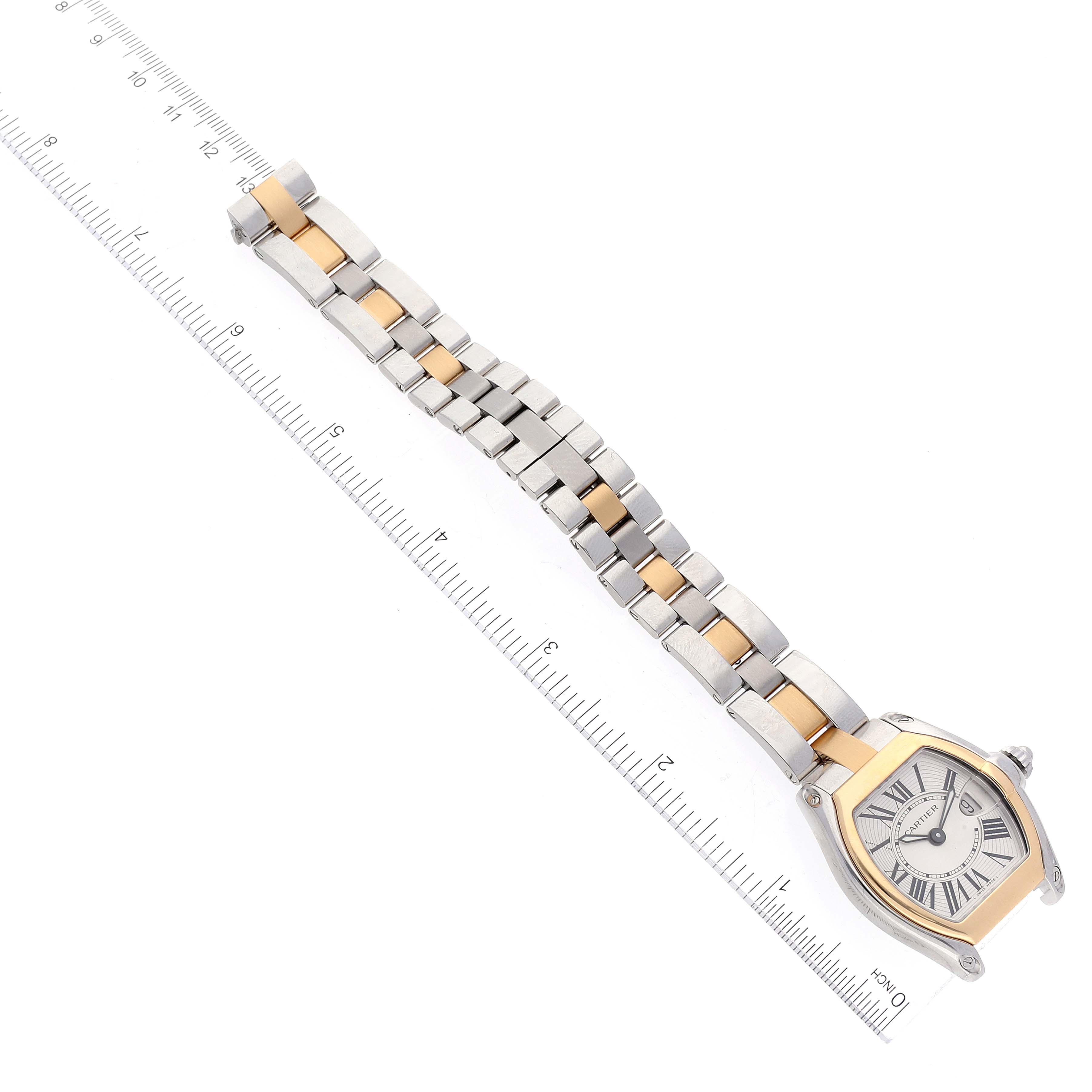 The image shows the Cartier Roadster W62026Y4 Women's Steel and Gold (two tone) Silver Dial W62026Y4 Women's Steel and Gold (two tone) Silver Dial watch laid flat on a ruler, displaying the entire bracelet and the watch face from a top-down angle.