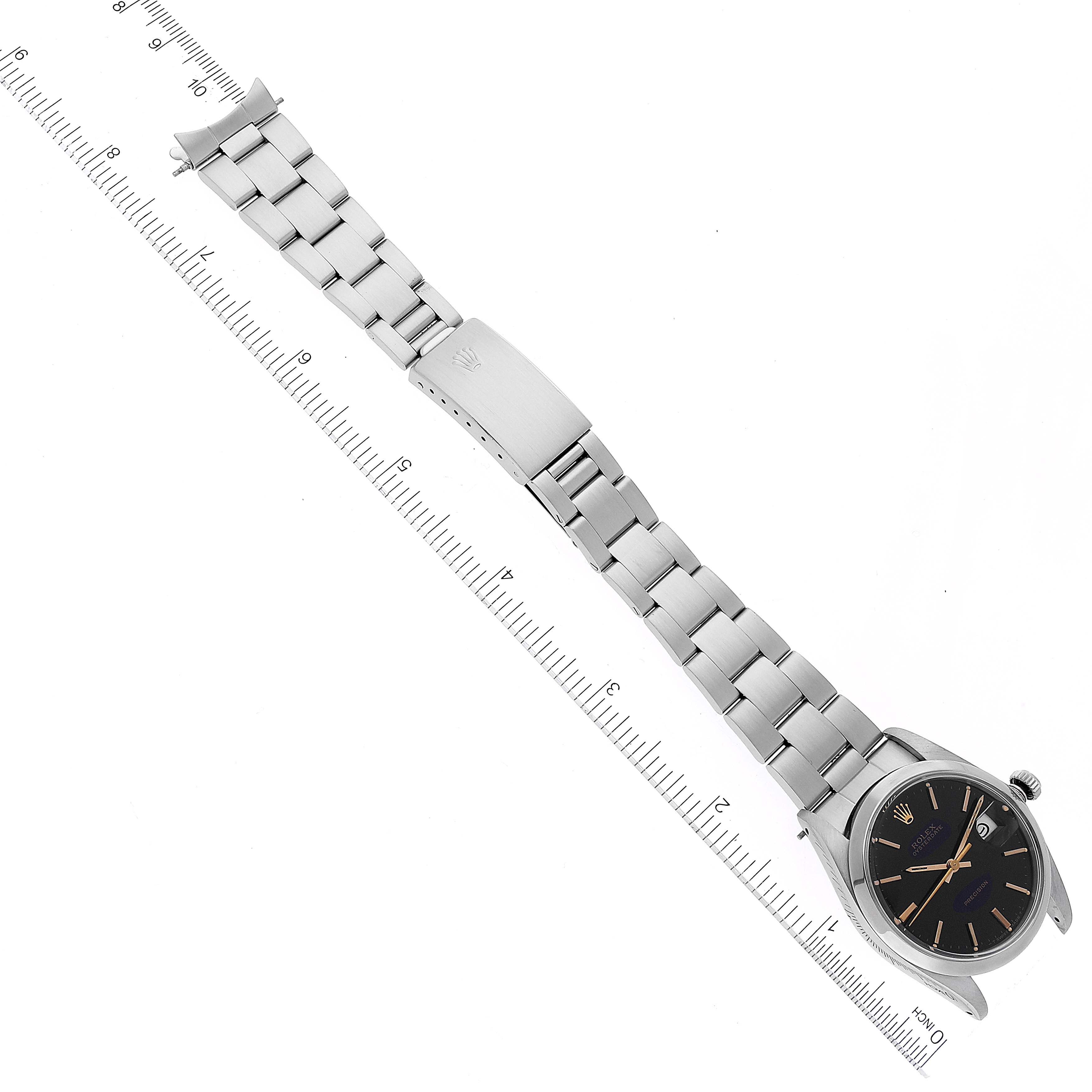 The image shows a Rolex Date 6694 Men's Stainless Steel Black Dial 6694 Men's Stainless Steel Black Dial model watch laid flat with its bracelet extended alongside a ruler for measurement.